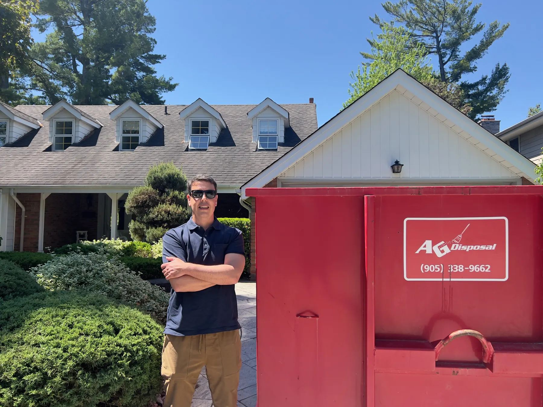 Andrew from AG Disposal beside a bin on a residential driveway